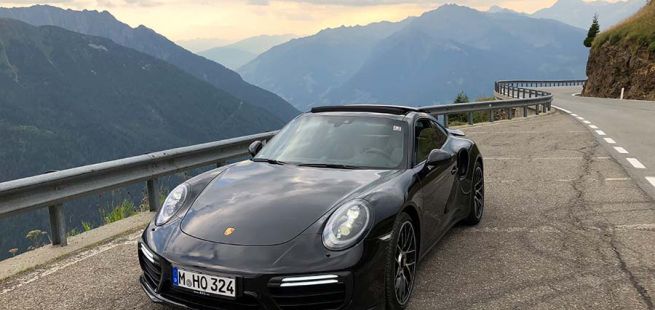 Porsche 911 Turbo S auf Passstraße mit Bergpanorama schräg links vorne