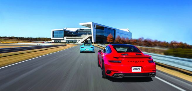 Roter Porsche 911 Turbo und miamiblauer 911 fahren auf Strecke des Porsche Experience Center Atlanta