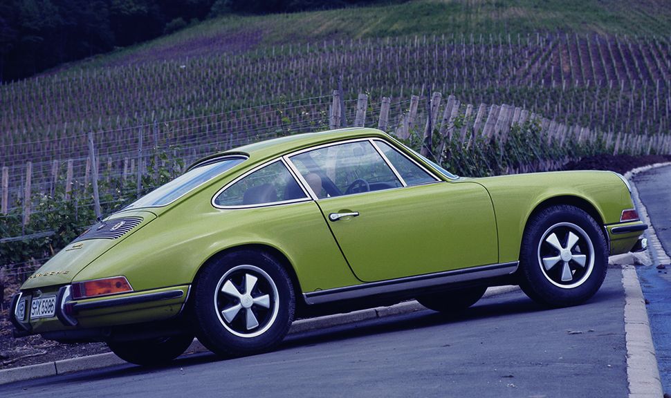 Grüner, alter Porsche 911 vor Weinberg stehend