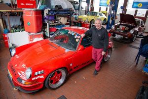 Herwig Roitmayer vor seinem roten Porsche 911 in seiner Werkstatt